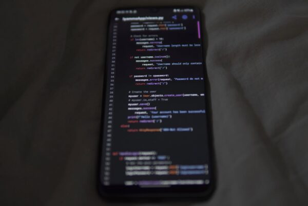Close-up of a smartphone showing Python code on the display, showcasing coding and technology.